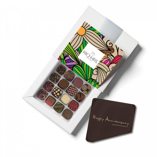 Box of 16 filled chocolates with 1 dark edible chocolate "Happy Anniversary ! " message card so the message is revealed when the box is opened.